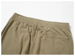 Close-up of the elastic waistband and back pocket of khaki men's sweatpants.