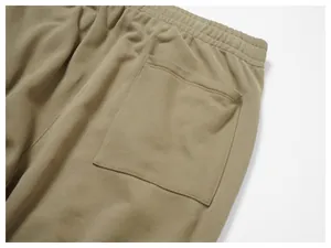 Close-up detail of khaki men's casual sweatpants showing back pocket and elastic waistband