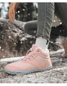 Botas descalzas de invierno rosas con forro polar en un paisaje de bosque nevado