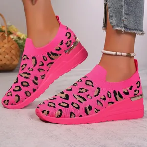 Close-up detail showing the leopard pattern on vibrant pink fly-knit wedge sneakers