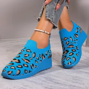 Detail shot of bright blue flyknit wedge sneakers featuring a trendy leopard print pattern