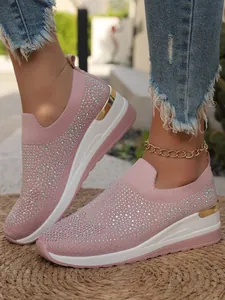 Dettaglio di sneaker in maglia rosa con strass e suola con zeppa platform bianca.