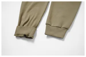 Dettaglio ravvicinato dei polsini a costine e del tessuto di qualità dei joggers verdi