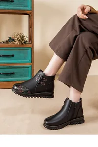 Detail der schwarzen lederstiefel mit pelzfutter, blumenakzenten und dicker sohle