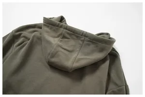 Dettaglio ravvicinato della felpa con cappuccio uomo verde militare con trama e cuciture