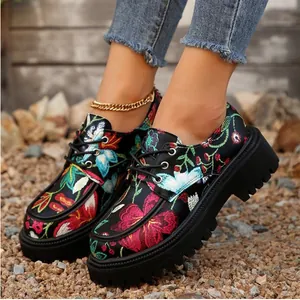 Primer plano de los bordados florales de colores en mocasines negros con plataforma
