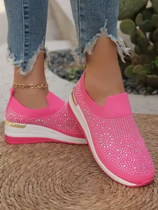 Primo piano di eleganti sneaker con zeppa rosa con decorazioni in strass sui piedi