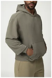 Detalle de una sudadera con capucha caqui de corte oversize con bolsillo canguro