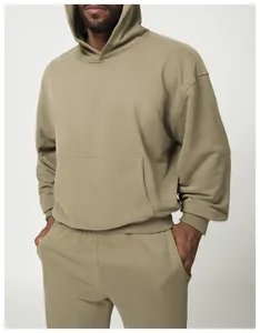 Detalle de sudadera con capucha oversize verde oliva con bolsillo canguro y puños acanalados