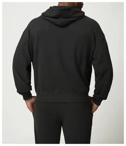 Vista trasera detallada de una sudadera deportiva negra minimalista con capucha y hombros