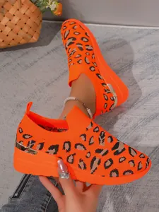 Detail of vibrant orange leopard print fly-knit sneakers with metallic heel accent