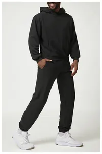 Vista de cuerpo entero de un hombre con sudadera negra extragrande y pantalón jogger.