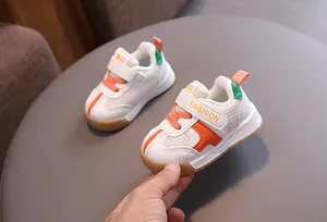 Detailed view of white breathable mesh baby walking shoes with orange Velcro straps