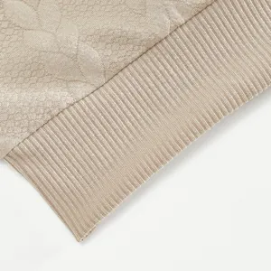 Detailansicht der feinen Textur von beige Jacquard-Strickstoff und elastischen Bündchen