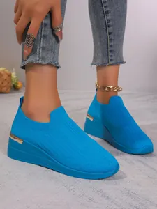 Vibrant blue fly-knit wedge sneakers for women, comfortable slip-on sporty detail.