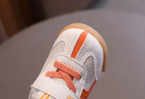 Detailed view of breathable orange mesh toddler sneakers with anti-collision rubber toe cap.
