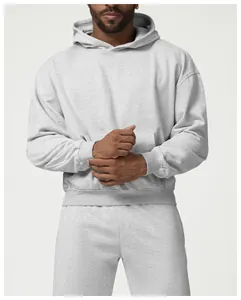 Primer plano de una sudadera con capucha gris claro de corte oversize y puños elásticos.