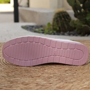 Vista dettagliata della suola in gomma rosa antiscivolo delle sneakers con zeppa da donna.