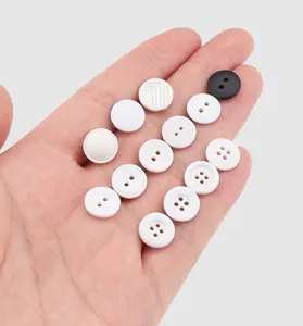 Close-up detail shot showing a variety of elegant white and black decorative buttons for clothing