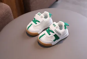 Detailed view of breathable white and green toddler mesh sneakers with velcro straps.