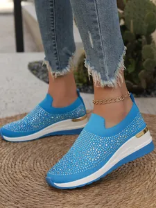 Dettaglio ravvicinato di scarpe platform blu con strass e suola a zeppa spessa