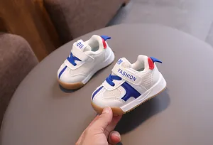 Detail view of white toddler sneakers with breathable mesh and blue accents for boys and girls.