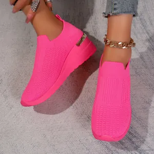 Detail view of hot pink fly-knit slip-on sneakers with breathable mesh texture.