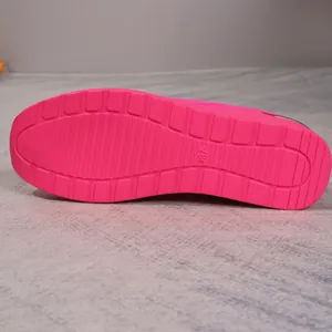 Detailed view of the pink anti-slip textured sole of a women's flyknit walking shoe