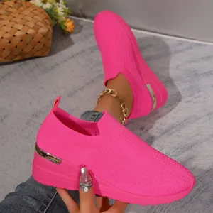Detailed macro view of breathable pink flyknit slip-on sneakers with metallic heel accent