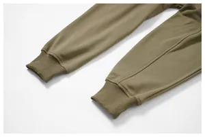 Primer plano de los puños acanalados en un pantalón de chándal verde oliva de calidad