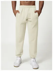 Close-up of men's cream-colored joggers featuring elastic waistband and cuffed ankles.
