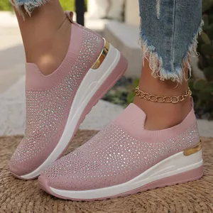 Dettaglio ravvicinato di sneakers rosa con strass e zeppa platform con bordo dorato