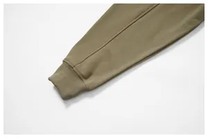 Primer plano detallado de la manga de la sudadera verde oliva con puño elástico acanalado