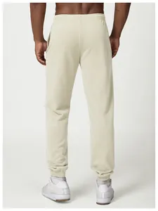 Back view detail of men's beige joggers showing elastic waistband and cuffed ankles