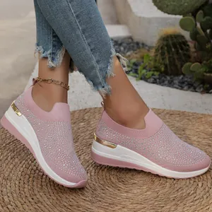 Vista laterale di eleganti sneakers con zeppa rosa e strass per donna con texture in maglia