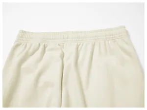 Close-up of the elasticated waistband and fabric texture on cream men's casual sweatpants