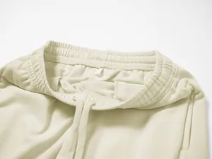 Detailed view of the elastic waistband and drawstring on men's beige casual joggers.