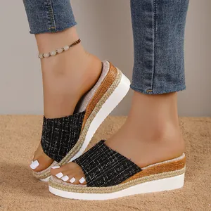 Gros plan de sandales compensées noires en tweed pour femmes avec détails de semelle