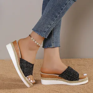 Vue latérale de sandales compensées pour femmes avec tige en tweed noir et semelle tressée.