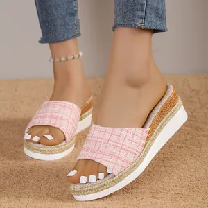 Détail de mules compensées en tweed rose avec bordure tressée et semelle blanche