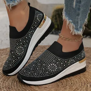 Primer plano de zapatillas con cuña negras para mujer con adornos de strass brillantes