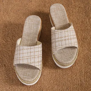 Gros plan détaillé de mules compensées pour femmes en lin à carreaux avec semelle tressée