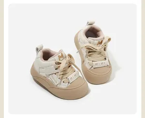 Dettaglio ravvicinato di scarpe primi passi per neonato color crema con punta in gomma