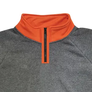 Detail view of the orange stand-up collar and black zipper on the grey sweatshirt.