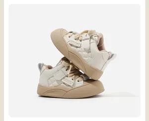 Primo piano di sneakers beige per neonati con design trapuntato e punta protettiva.