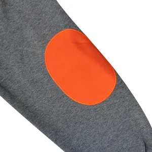 Close-up detail of grey sweatshirt sleeve featuring a contrasting orange elbow patch