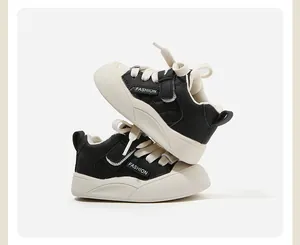 Vista laterale dettagliata di scarpe primi passi neonato nere e bianche trapuntate.