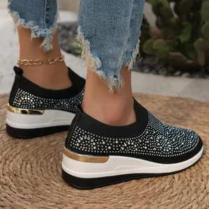 Dettaglio di sneakers con zeppa da donna con strass scintillanti e suola spessa.