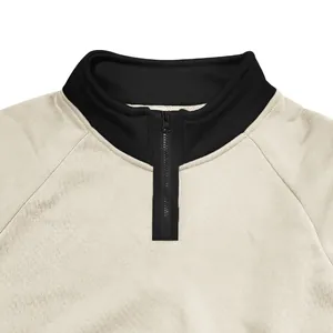 Close-up detail of a beige heavyweight sweatshirt with a black quarter-zip stand collar