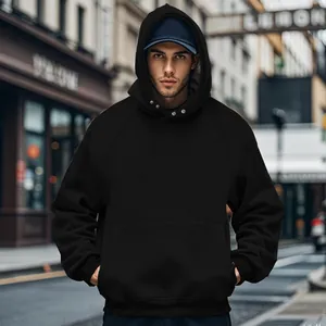 Detail shot of a black oversized hoodie with a front pocket and ribbed sleeve cuffs
